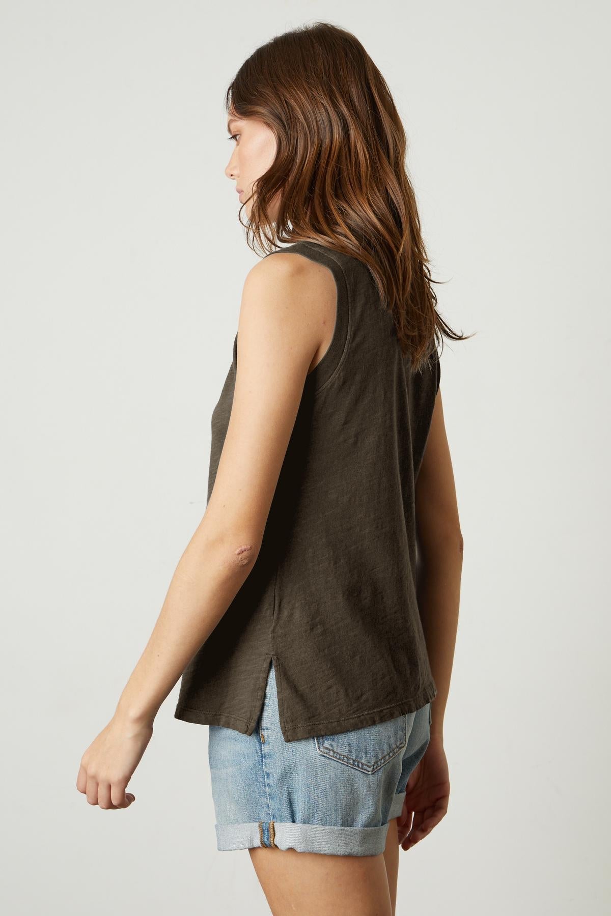   The back view of a woman wearing ELLEN VINTAGE SLUB TANK TOP by Velvet by Graham & Spencer denim shorts and a sleeveless tank top. 
