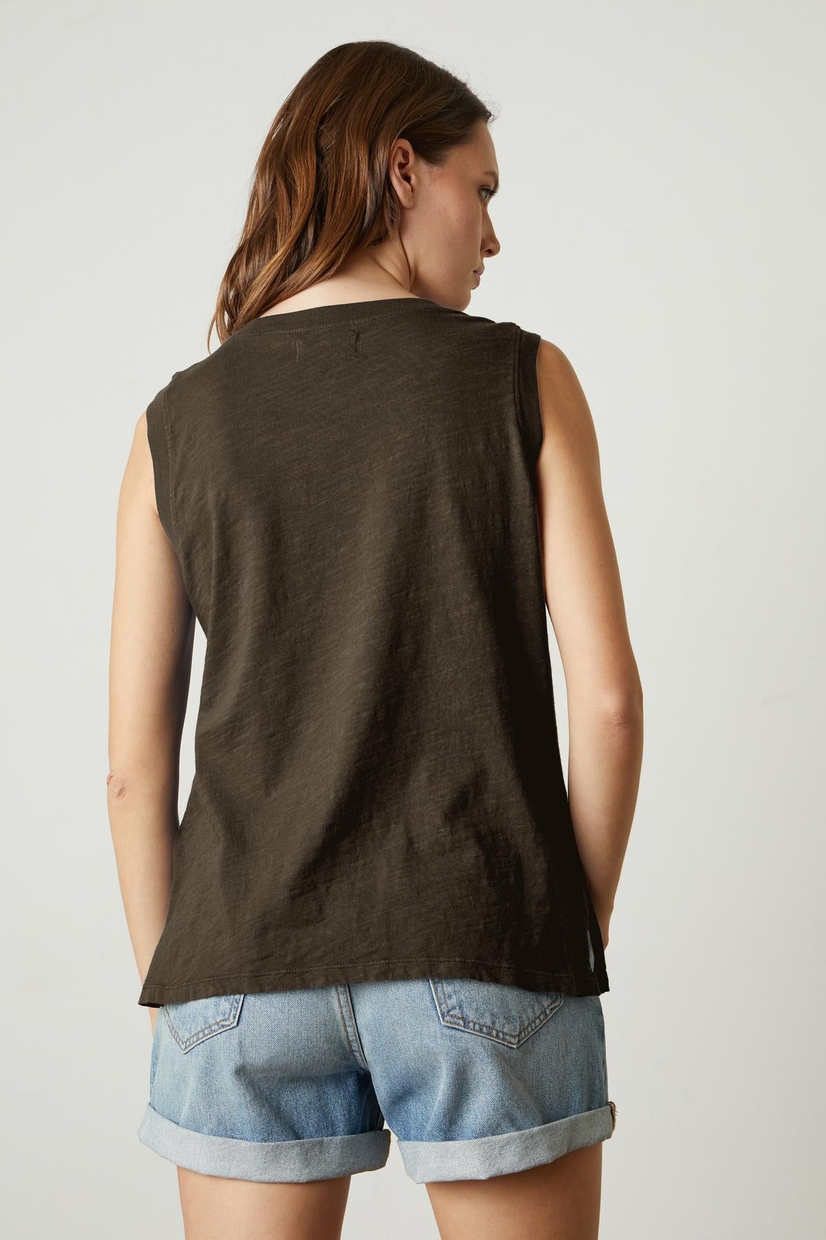   The back view of a woman wearing a Velvet by Graham & Spencer ELLEN VINTAGE SLUB TANK TOP and denim shorts. 