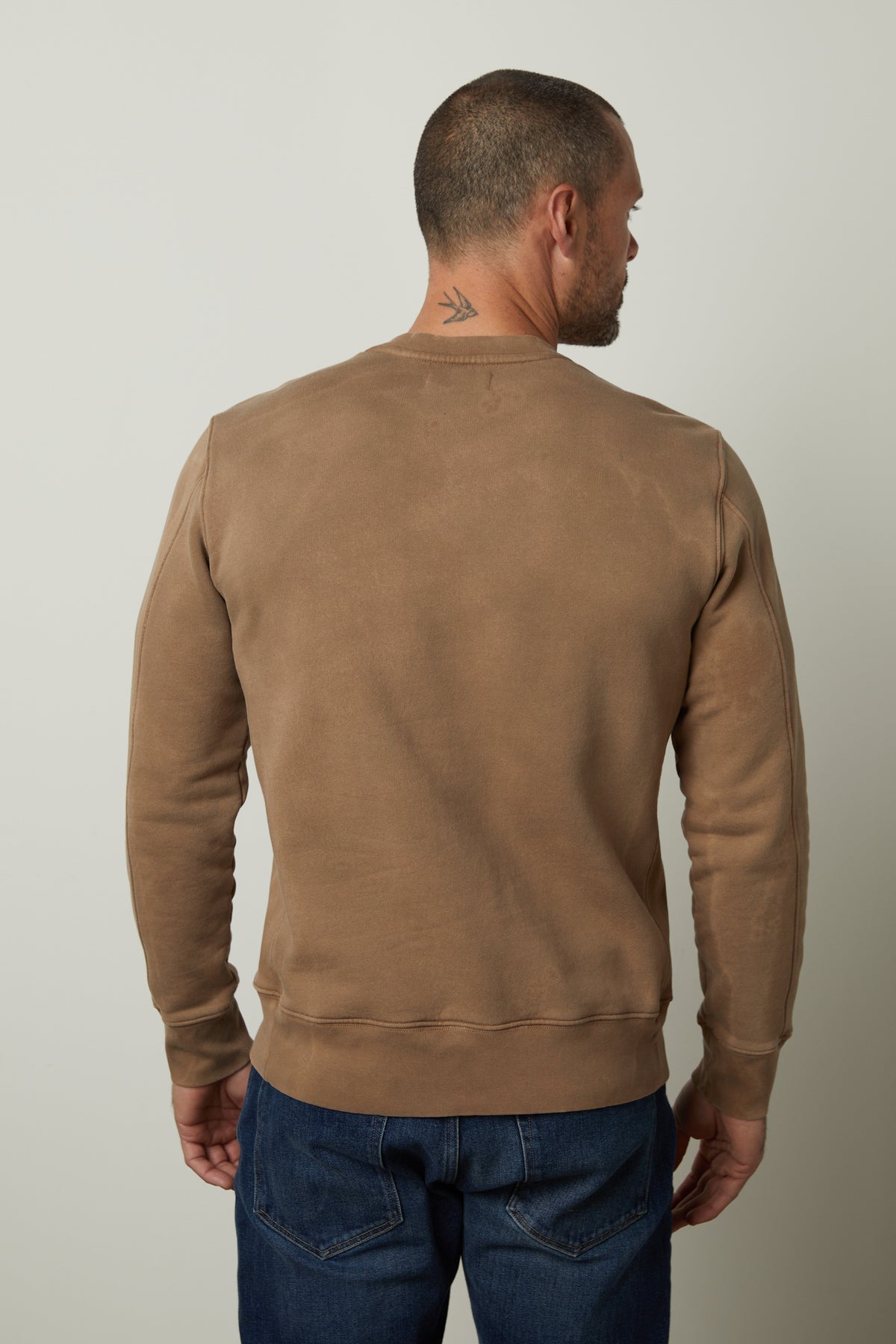   The back view of a man wearing a Velvet by Graham & Spencer MATTS CREW NECK SWEATSHIRT for comfort and warmth. 