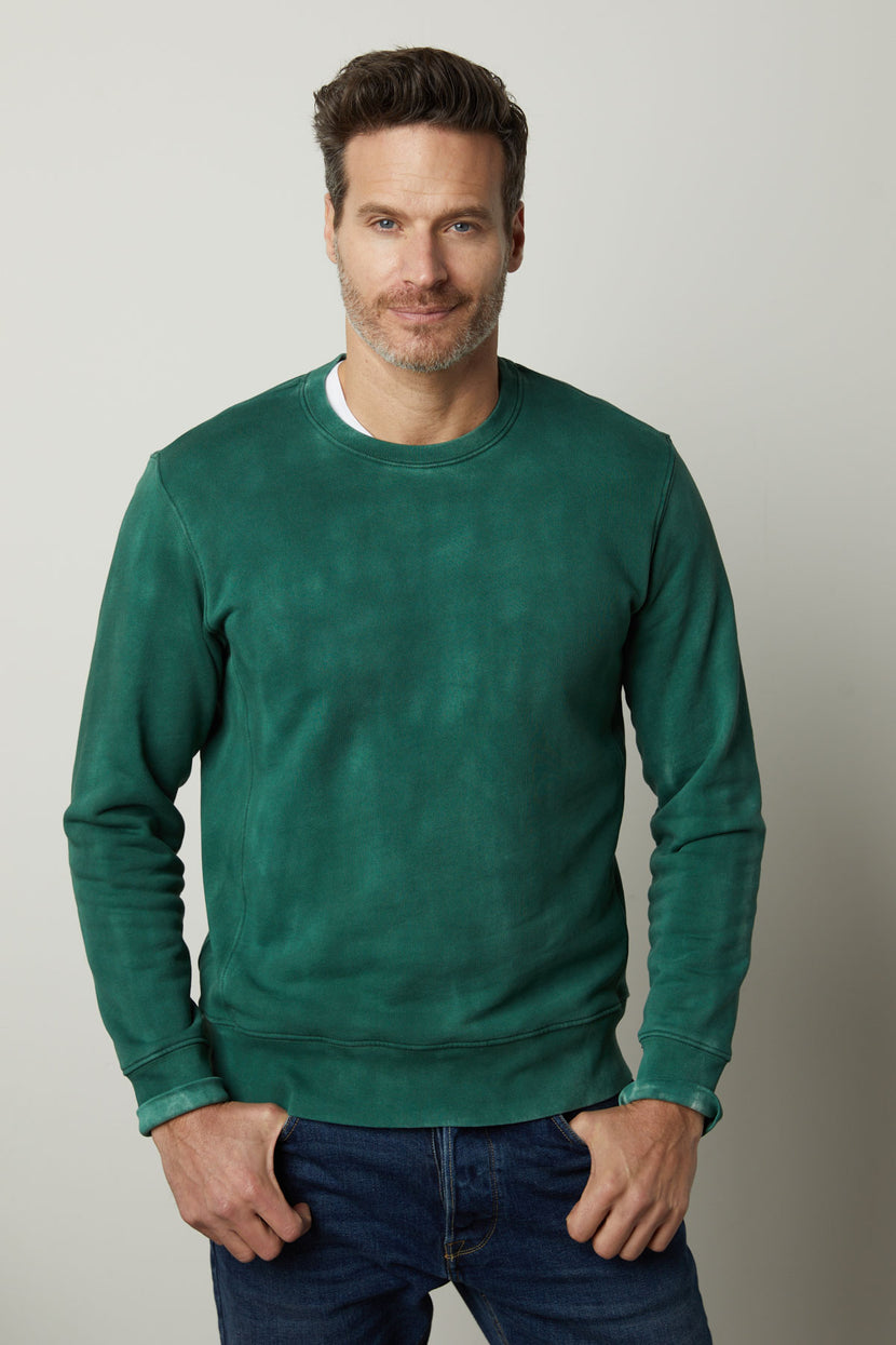 A man wearing a Velvet by Graham & Spencer MATTS CREW NECK SWEATSHIRT made of cozy fleece material.