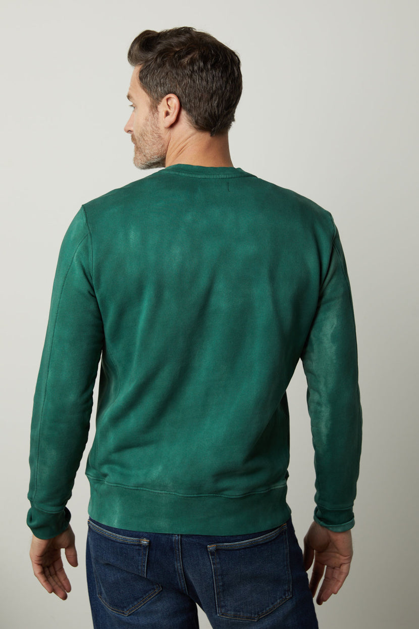 The back view of a man wearing a Velvet by Graham & Spencer MATTS CREW NECK SWEATSHIRT, providing comfort and warmth as he stays cozy in fleece.