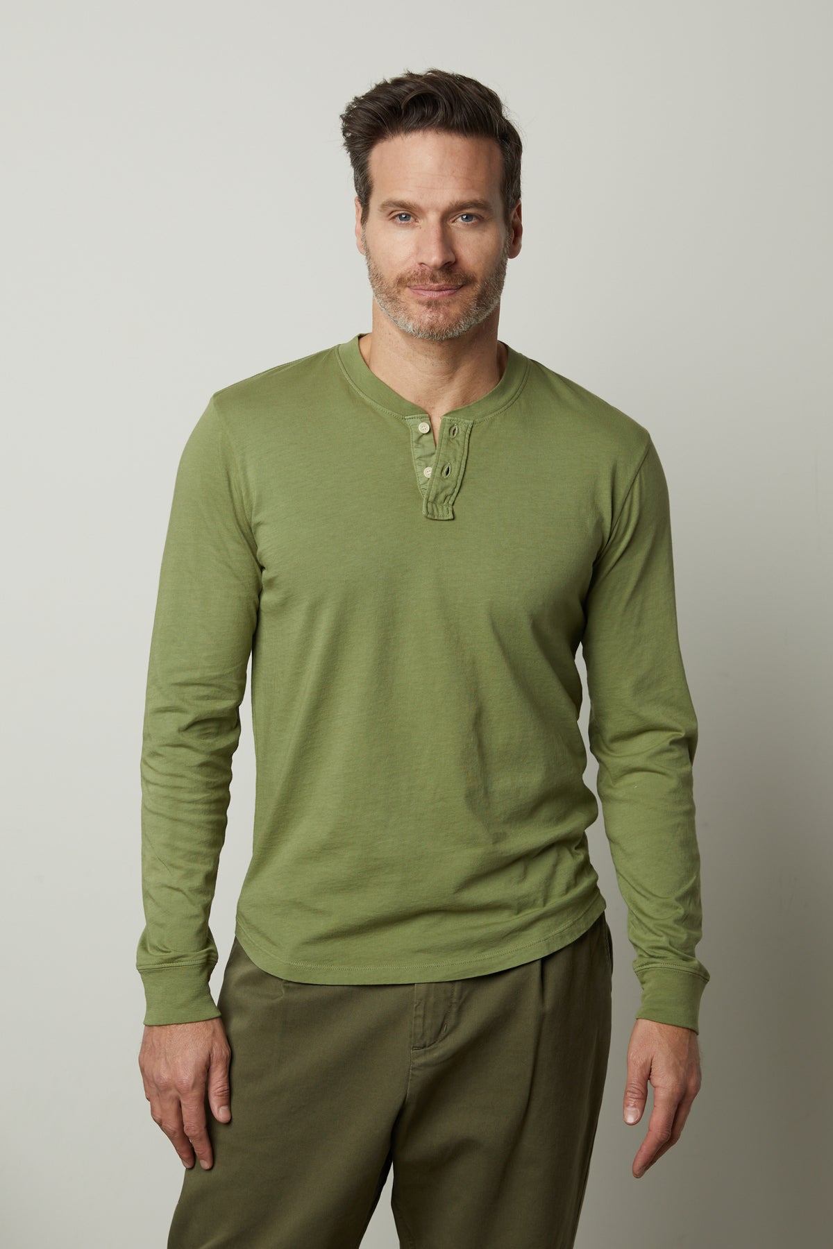 A man wearing a green Velvet by Graham & Spencer Braden Henley t-shirt.-35567416639681