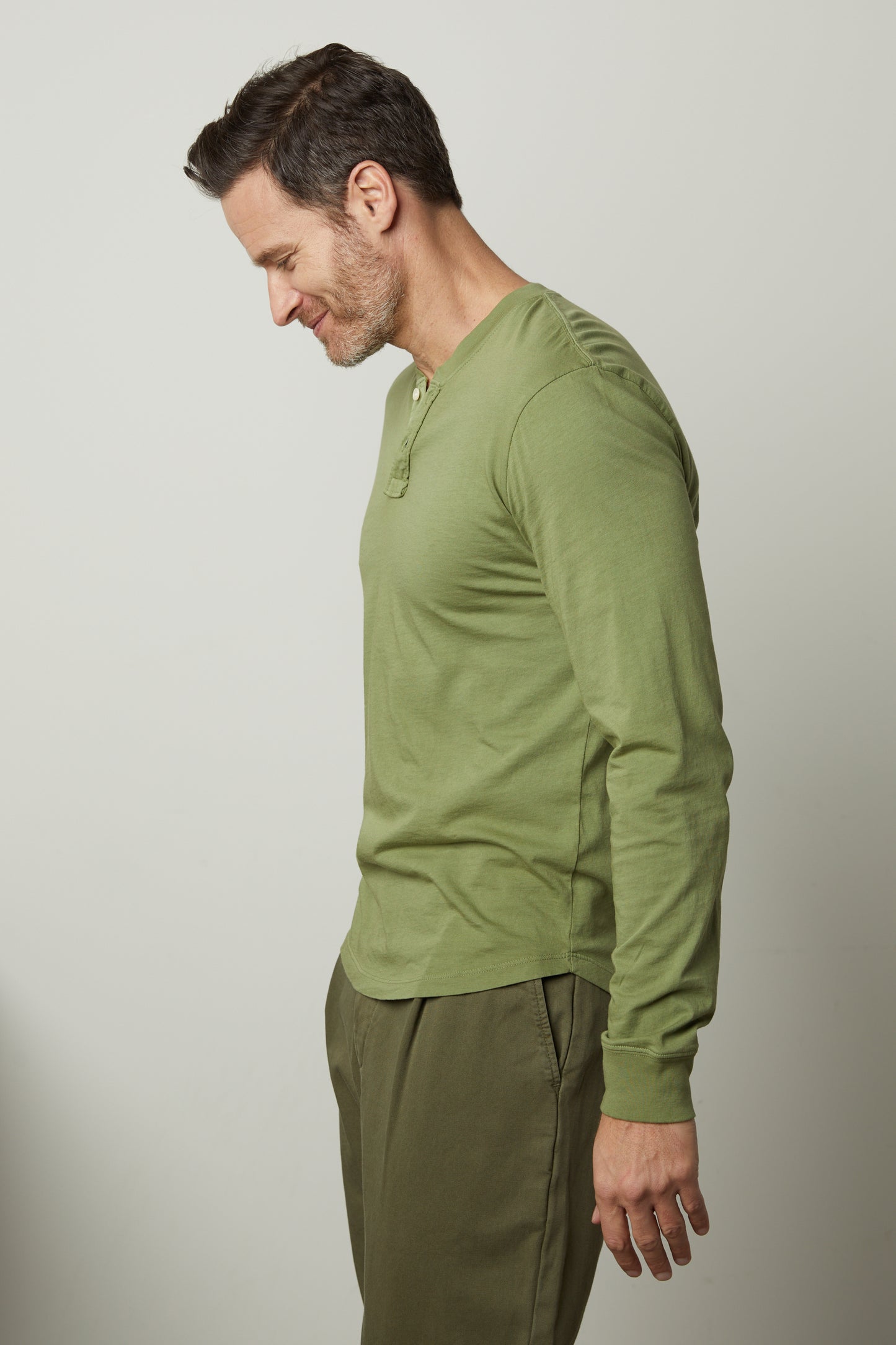 A man wearing the Velvet by Graham & Spencer BRADEN HENLEY shirt and green pants.-26679199957185