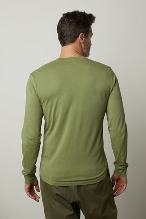 The back view of a man wearing a green BRADEN HENLEY long-sleeved shirt by Velvet by Graham & Spencer.