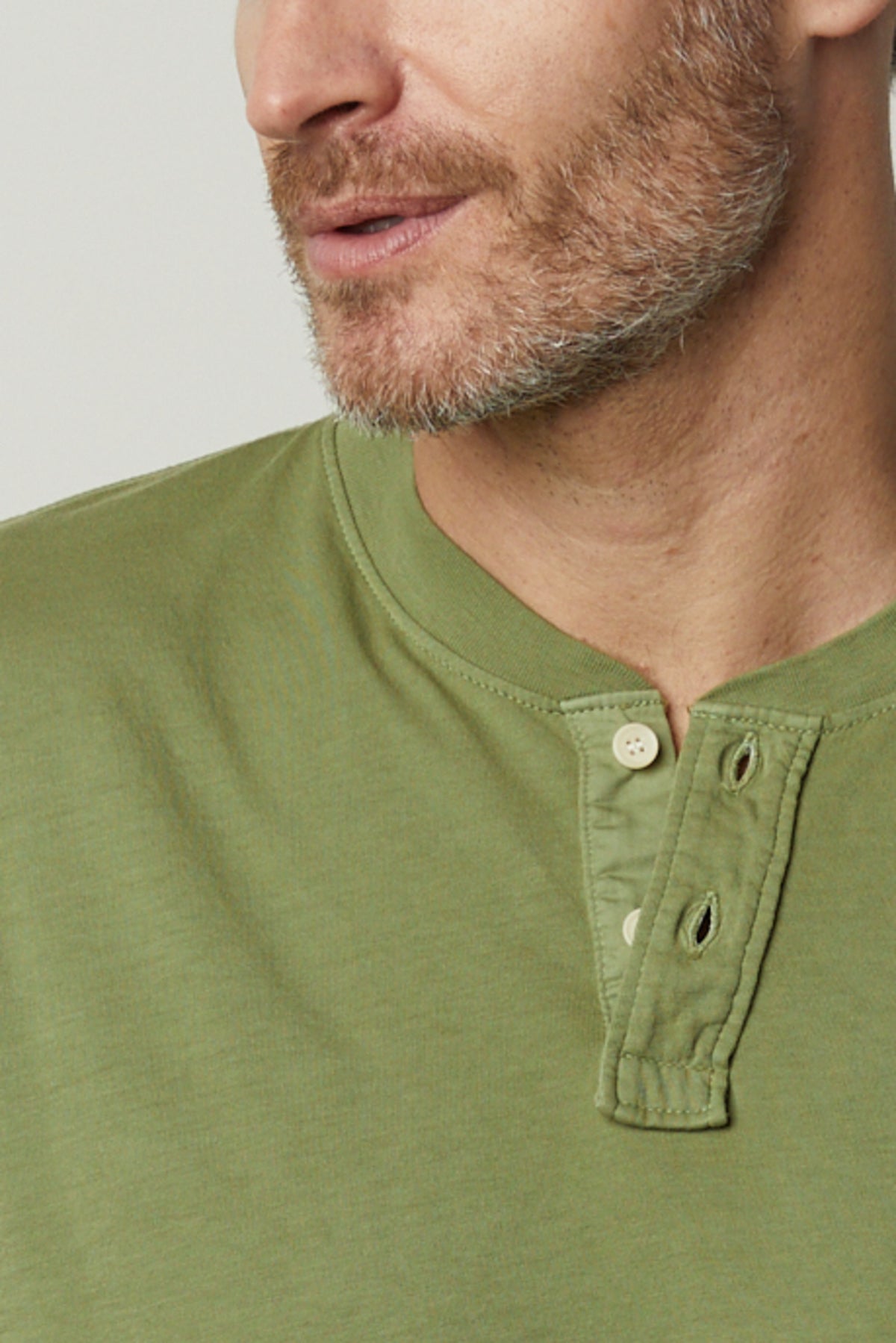 A man wearing a green Velvet by Graham & Spencer Braden Henley shirt.-35567416803521