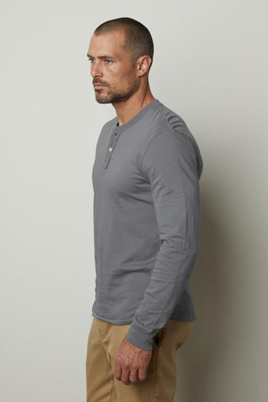 A man in a versatile gray Velvet by Graham & Spencer BRADEN HENLEY shirt and khaki pants.