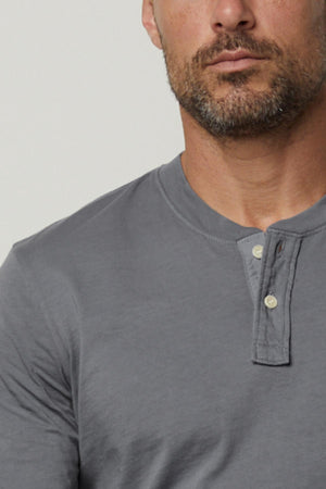 A man in a versatile grey BRADEN HENLEY shirt by Velvet by Graham & Spencer made of cotton fabric.
