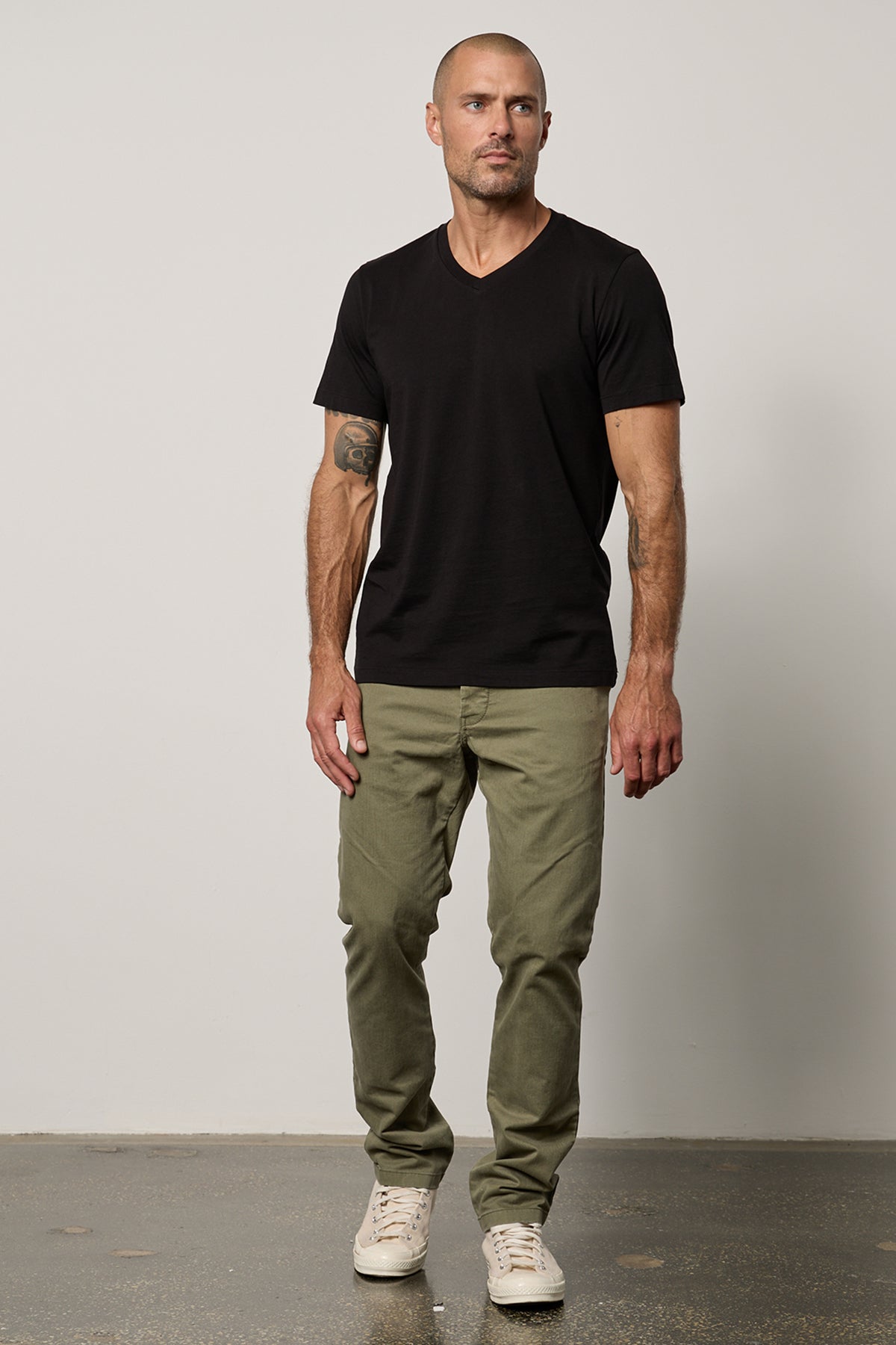   a man wearing MARSHALL V-NECK TEE by Velvet by Graham & Spencer pants and a black t-shirt. 
