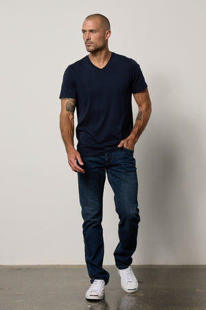 a man wearing jeans and a Velvet by Graham & Spencer MARSHALL V-NECK TEE.