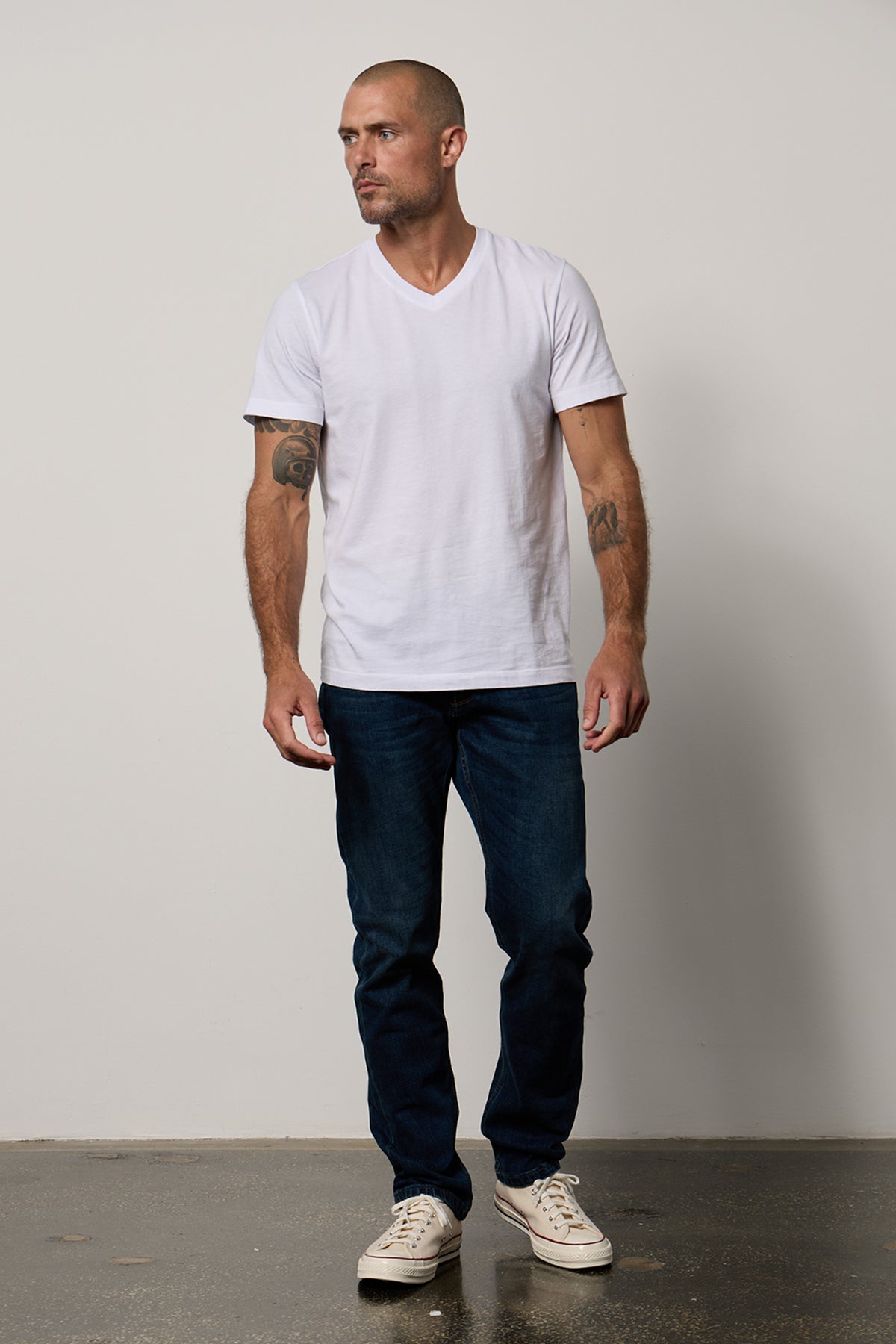 A man wearing a white Velvet by Graham & Spencer MARSHALL V-NECK TEE and jeans.-26514078269633