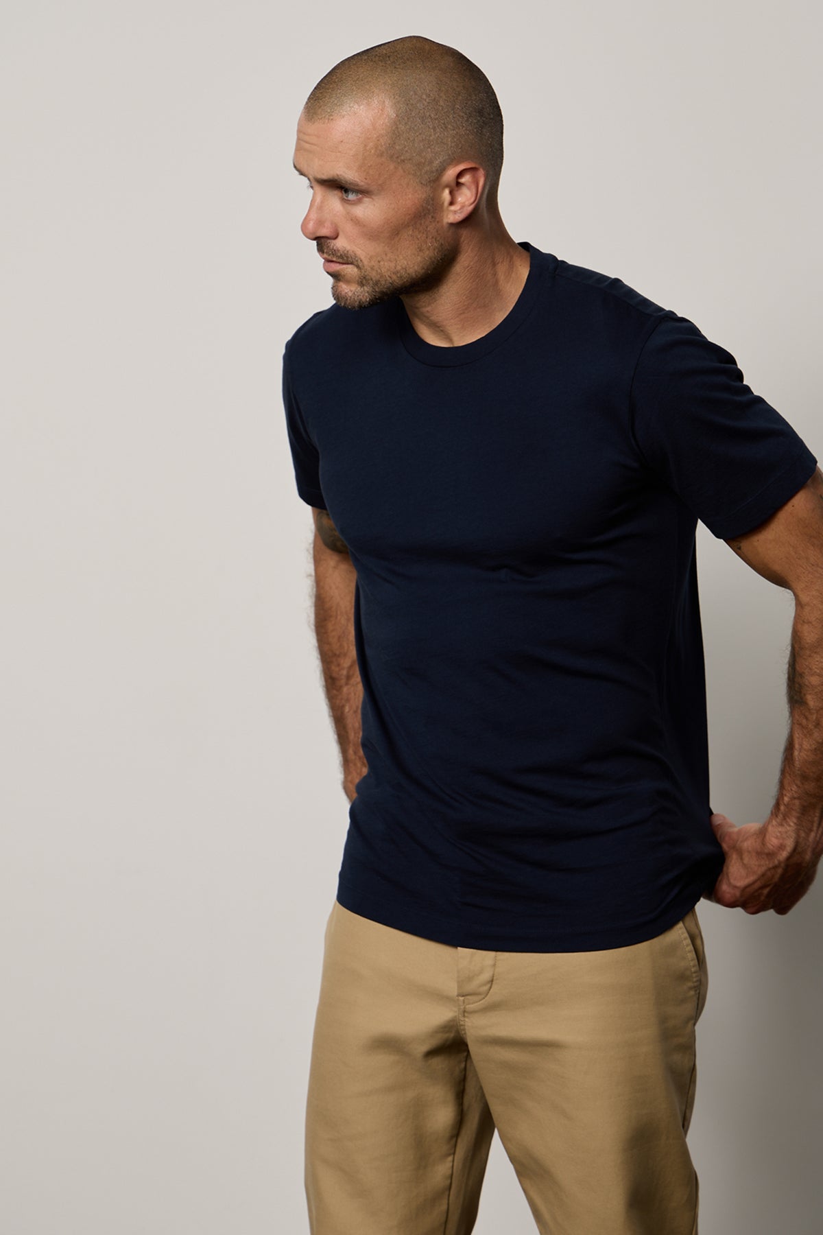   a man wearing a Velvet by Graham & Spencer RANDY CREW NECK TEE and khaki pants. 