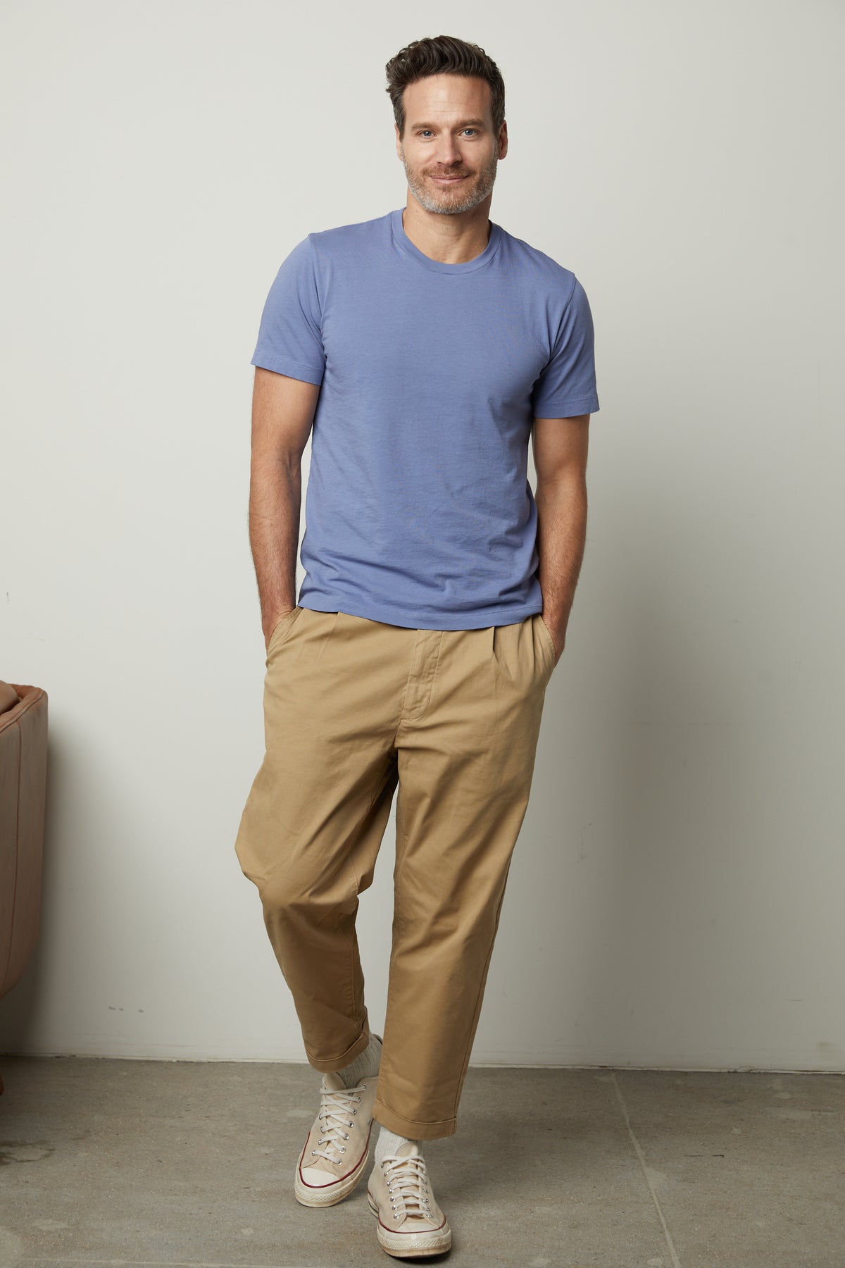   A man wearing a Velvet by Graham & Spencer RANDY CREW NECK TEE and khaki pants. 