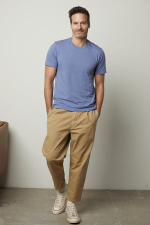 A man wearing a Velvet by Graham & Spencer RANDY CREW NECK TEE and khaki pants.