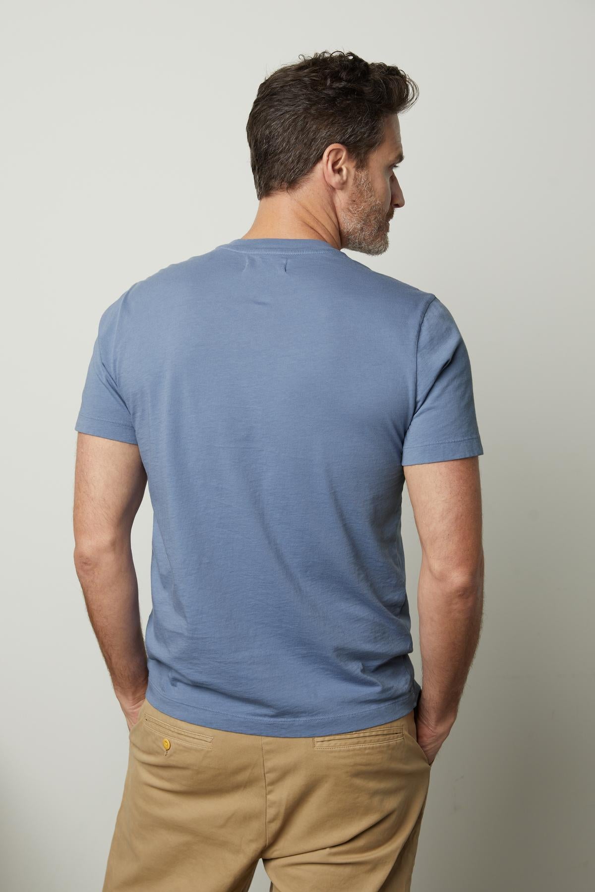   The back of a man wearing a Velvet by Graham & Spencer Randy Crew Neck Tee and khaki pants. 