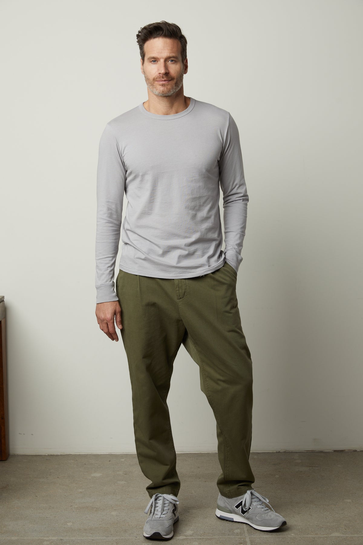 A man wearing a Velvet by Graham & Spencer grey long-sleeved STRAUSS CREW NECK TEE and khaki pants.-26846183129281