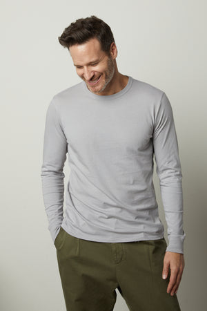A man wearing a Velvet by Graham & Spencer STRAUSS CREW NECK TEE and green pants.