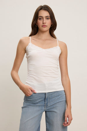 A woman faces forward against a plain light background, wearing the INDIE LACE CAMI by Velvet by Graham & Spencer with light blue jeans.