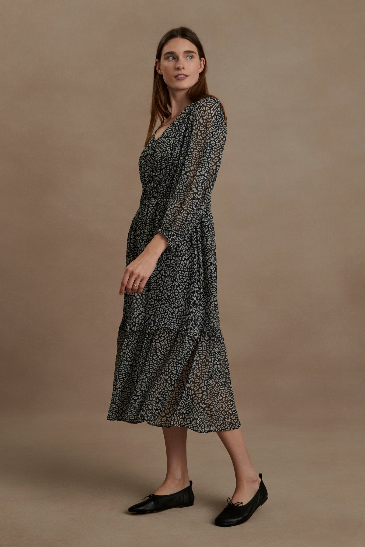 The model is wearing a Velvet by Graham & Spencer LESLIE PRINTED BOHO DRESS with a flared skirt.-35630472134849