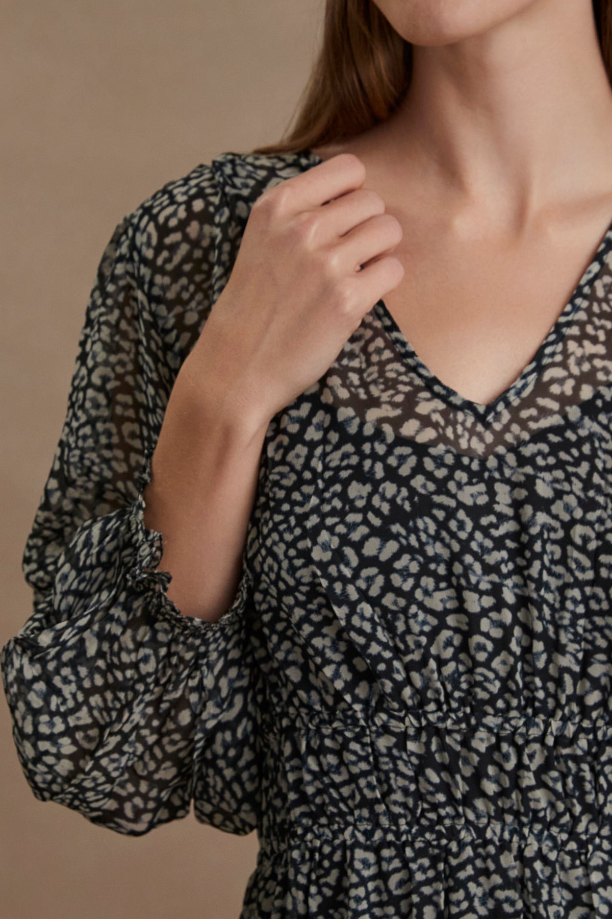   A woman wearing a Velvet by Graham & Spencer Leslie Printed Boho Dress, a lightweight black and white leopard print top with a viscose georgette overlay and flared skirt. 