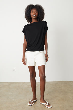 The model is wearing a Velvet by Graham & Spencer PAULINA VISCOSE JERSEY TOP and white shorts.