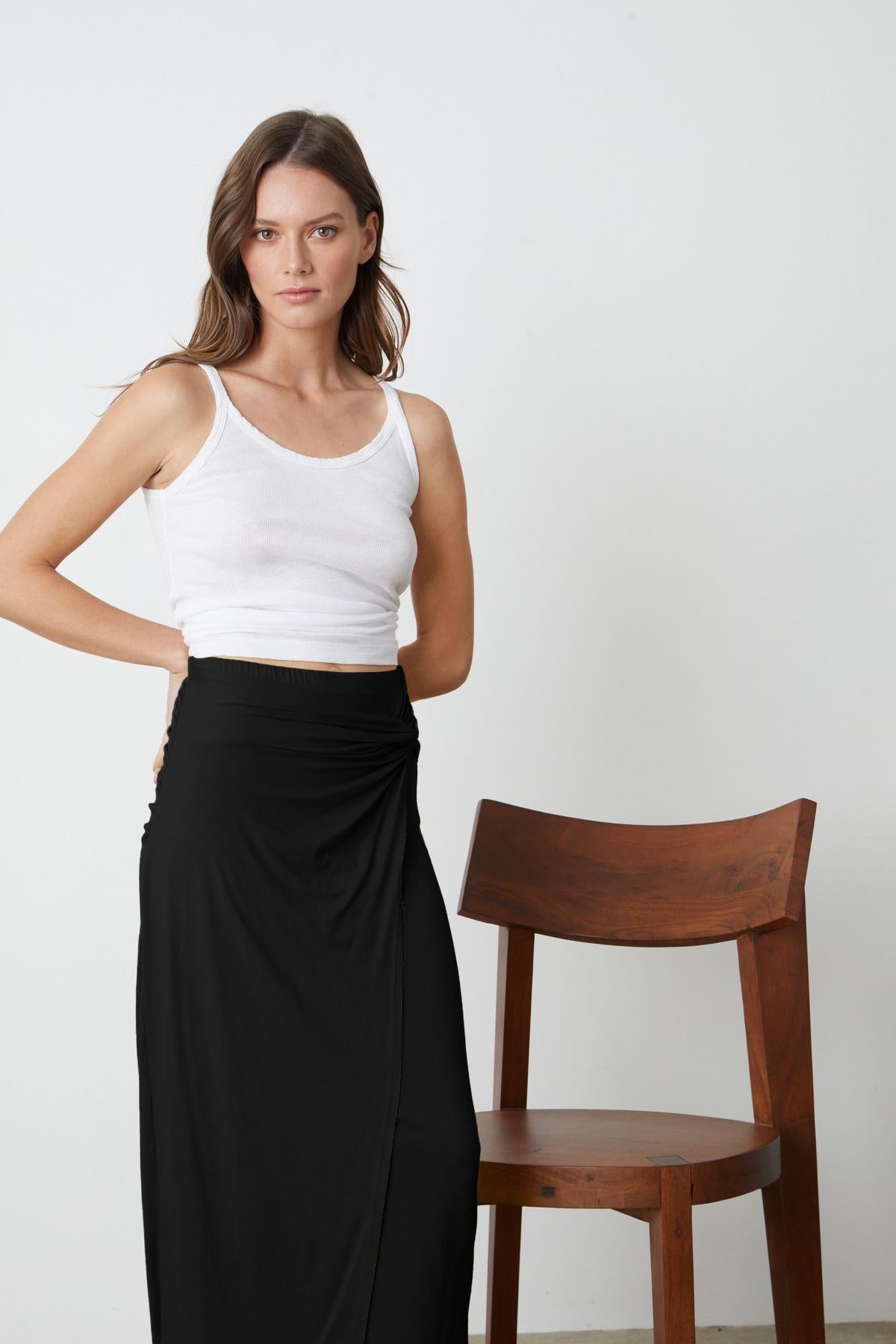   A person wearing a SHAE TWIST FRONT SKIRT by Velvet by Graham & Spencer and white top. 