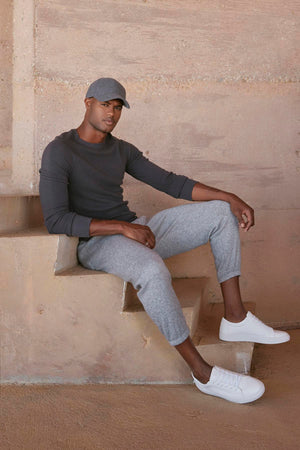 A man wearing a grey Velvet by Graham & Spencer hat and grey Velvet by Graham & Spencer sweatpants with a comfortable fit.