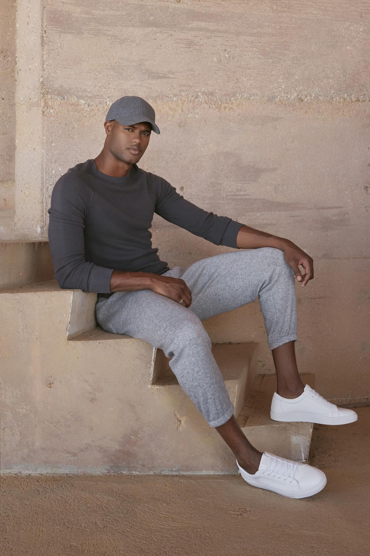 A man sitting on steps wearing Velvet by Graham & Spencer's SALINGER DOUBLE KNIT SWEATPANT.-35231597854913