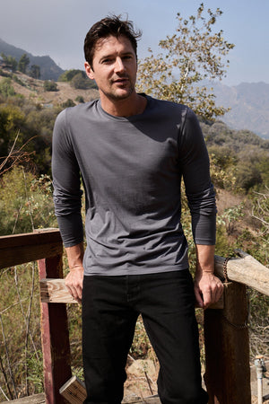 Model standing outdoors wearing Skeeter Crew Neck Long Sleeve Tee in ink front