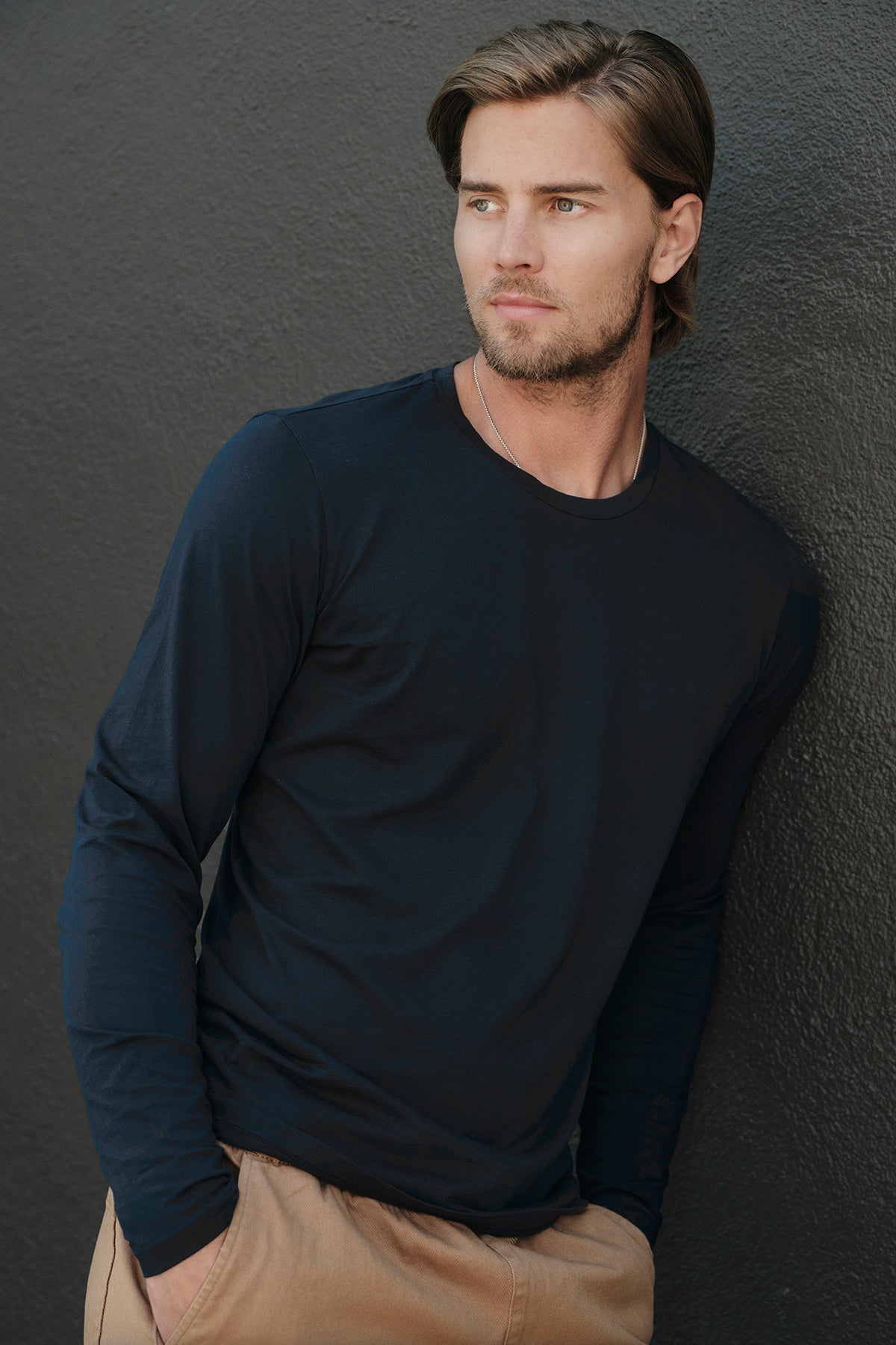 A man in a black long sleeve SKEETER WHISPER CLASSIC CREW NECK TEE, a perfect layering piece for the cooler months by Velvet by Graham & Spencer.-35783155417281