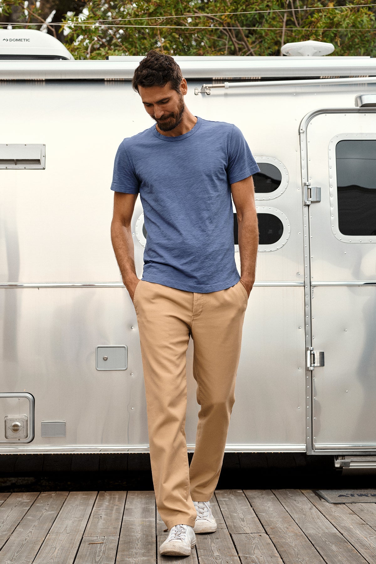   A man wearing a Velvet by Graham & Spencer AMARO CREW NECK SLUB TEE and khaki pants in front of an airstream trailer. 