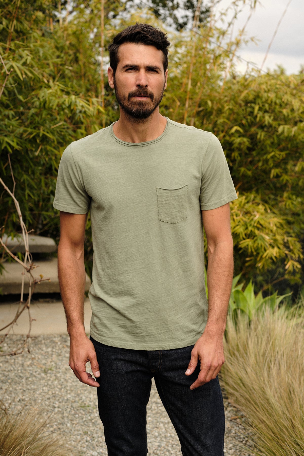   a man wearing a Velvet by Graham & Spencer CHAD RAW EDGE COTTON SLUB POCKET TEE and jeans. 