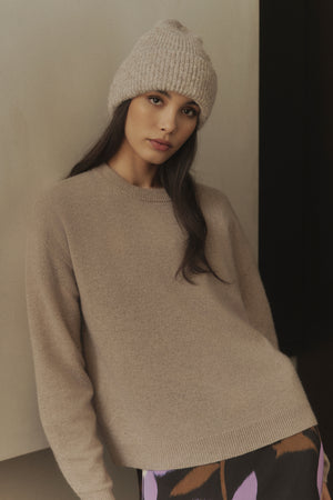 The model is wearing an ECO CUFF BEANIE by Velvet by Graham & Spencer and a floral skirt, perfect for cold weather.