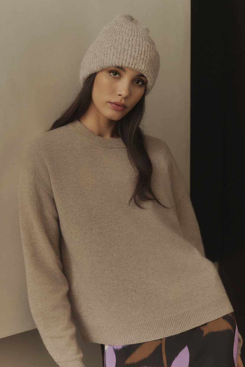The model is wearing an ECO CUFF BEANIE by Velvet by Graham & Spencer and a floral skirt, perfect for cold weather.