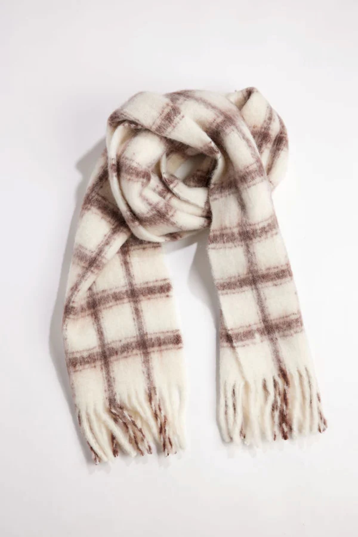 The WARM WINDOW PLAID SCARF by Velvet by Graham & Spencer features a white base with a brown plaid pattern and fringed ends, shown laid flat on a white background.