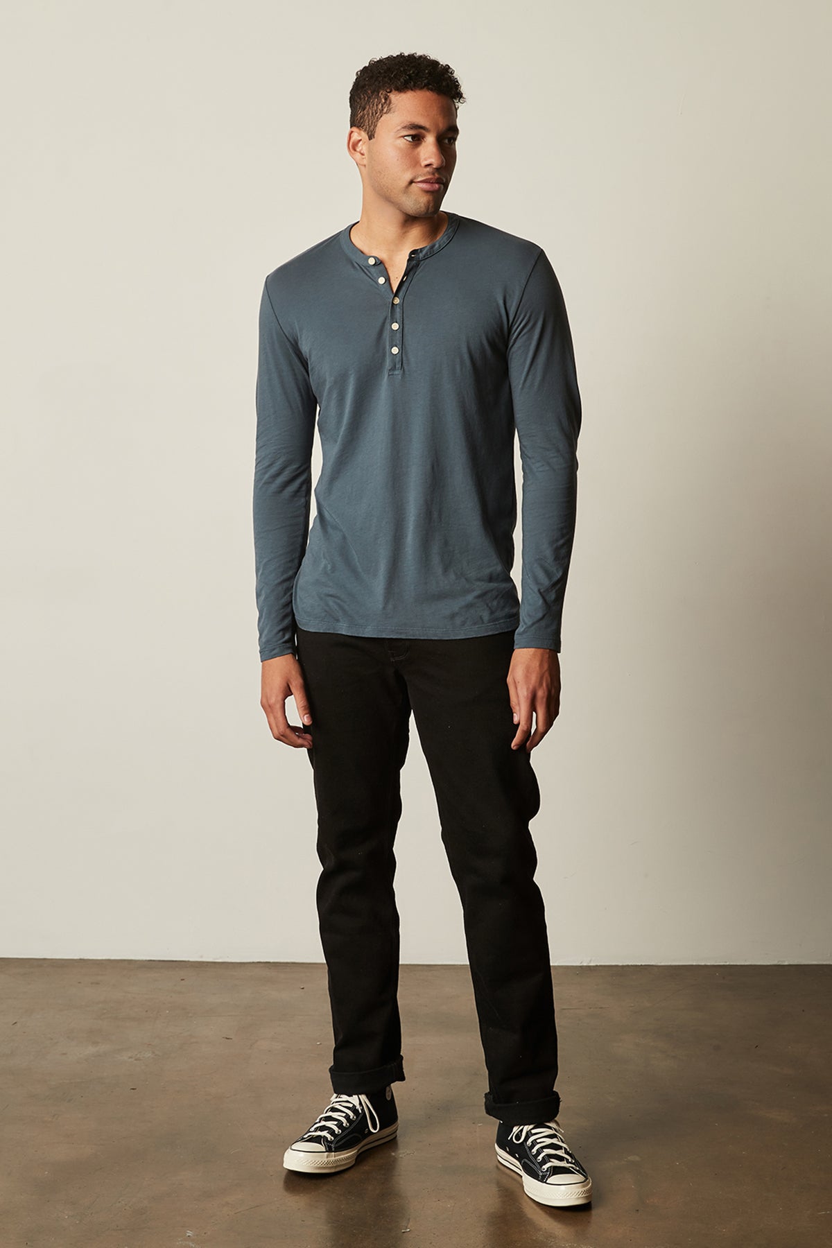 a man wearing a blue ALVARO COTTON JERSEY HENLEY shirt from Velvet by Graham & Spencer and black pants.-26629718376641