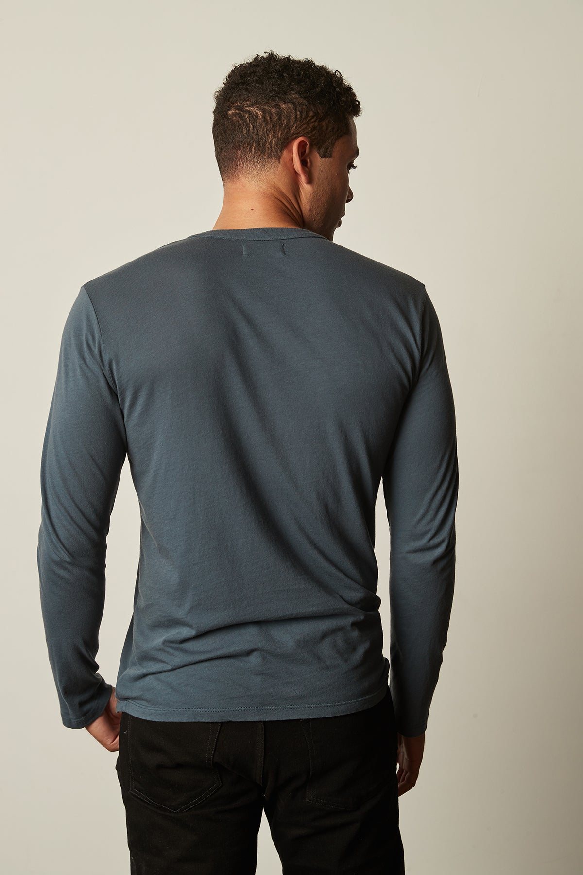   the back view of a man wearing a Velvet by Graham & Spencer ALVARO COTTON JERSEY HENLEY blue long sleeve t-shirt. 