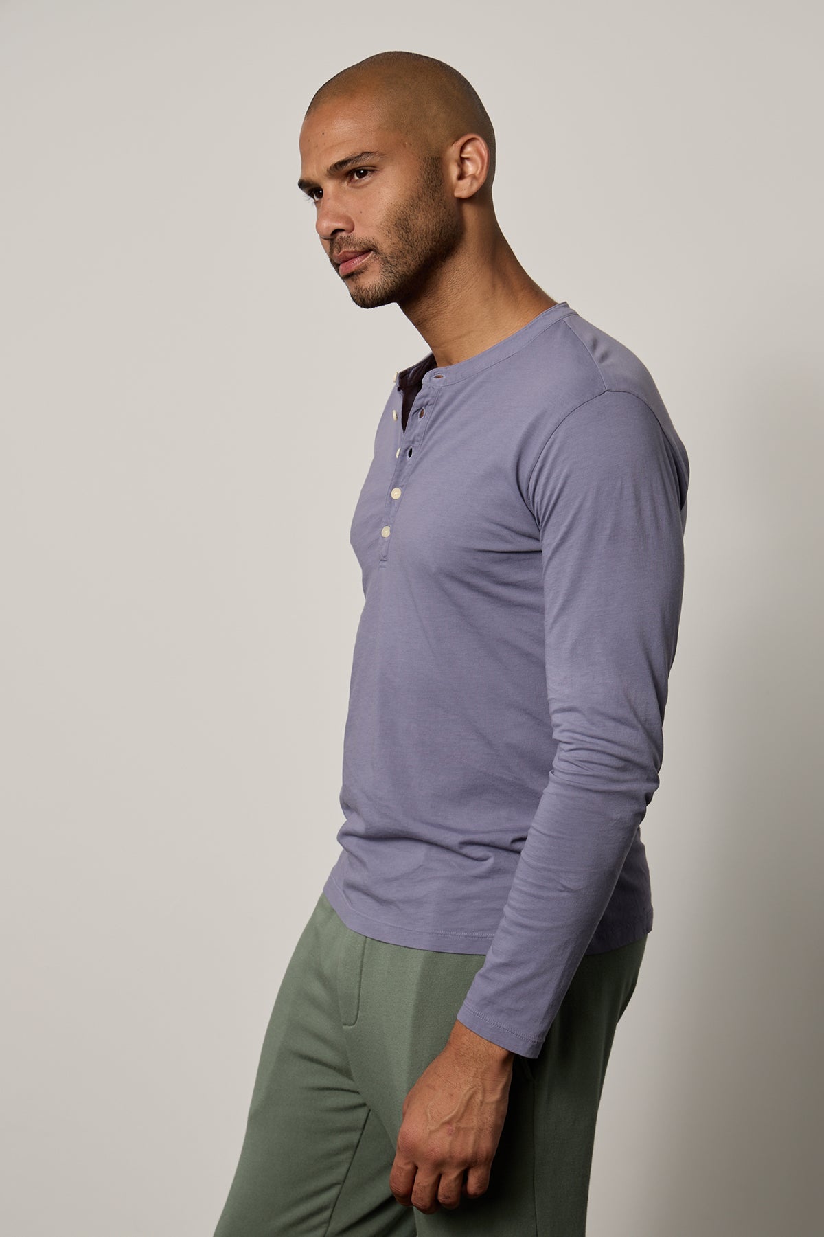   a man wearing a purple Velvet by Graham & Spencer ALVARO COTTON JERSEY HENLEY shirt and green pants. 