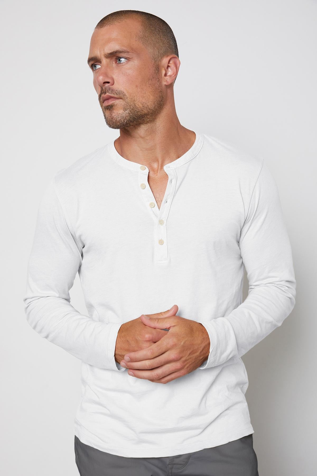   A man in a lightweight white Velvet by Graham & Spencer ALVARO COTTON JERSEY HENLEY t-shirt. 