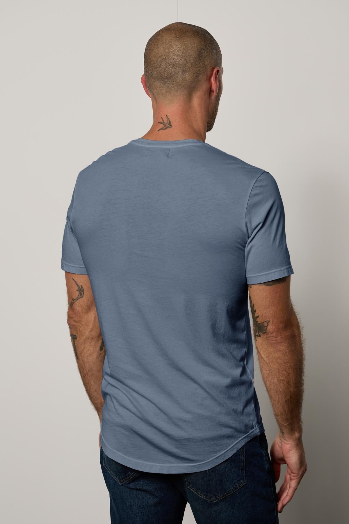   The back of a man wearing a Velvet by Graham & Spencer Fulton Short Sleeve Henley t-shirt. 