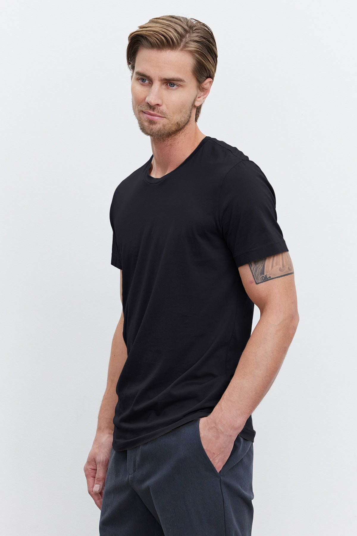  A man wearing a lightweight cotton knit black Velvet by Graham & Spencer HOWARD WHISPER CLASSIC CREW NECK TEE and black pants. 