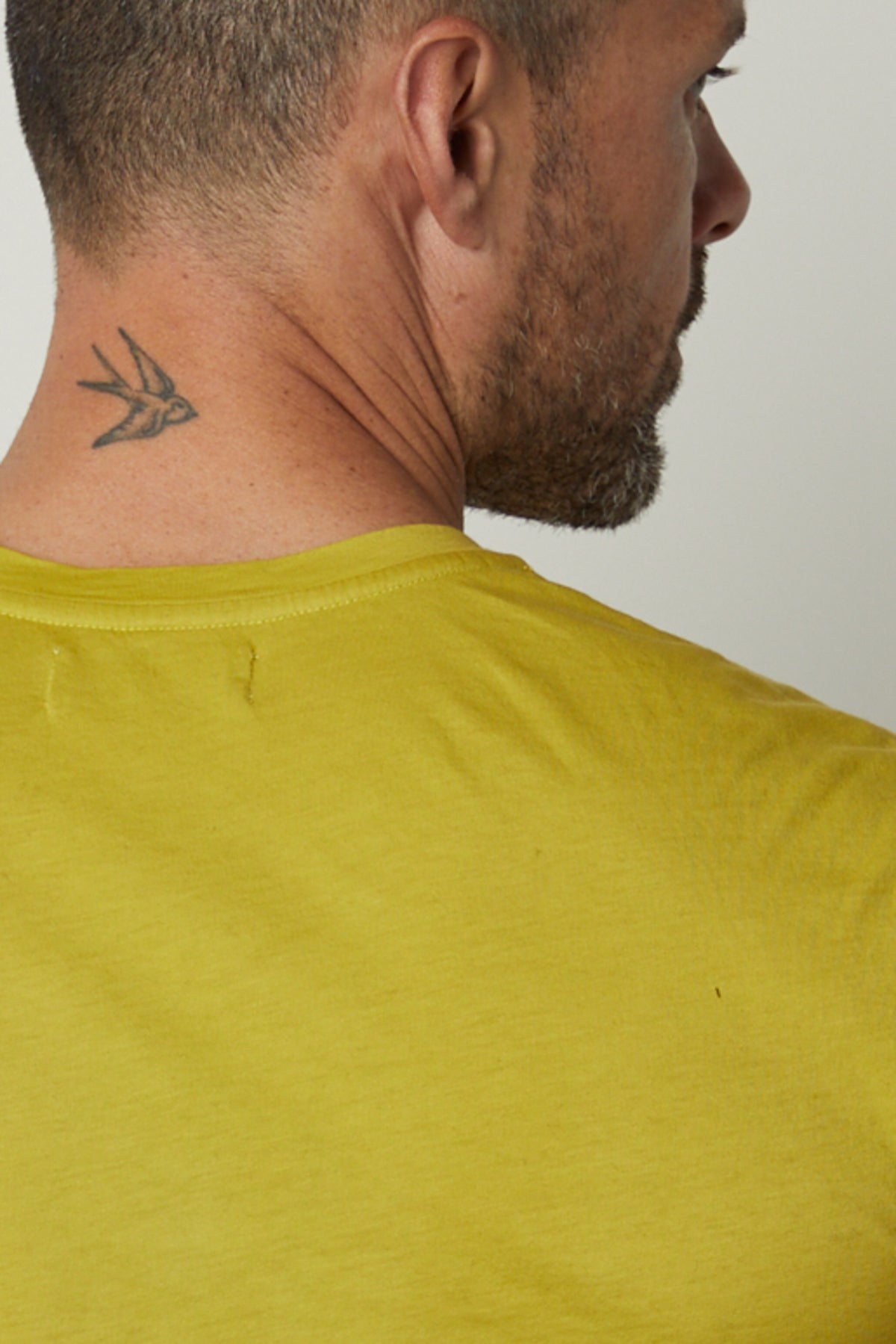   A man wearing a Velvet by Graham & Spencer HOWARD WHISPER CLASSIC CREW NECK TEE with a tattoo on his back. 