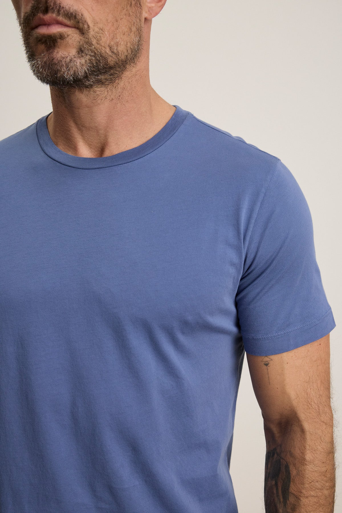 Model wears the HOWARD TEE by Velvet by Graham & Spencer—a fitted, short-sleeve light blue Pima jersey shirt—shown from shoulders to mid-arm against a plain background.-40606036099265