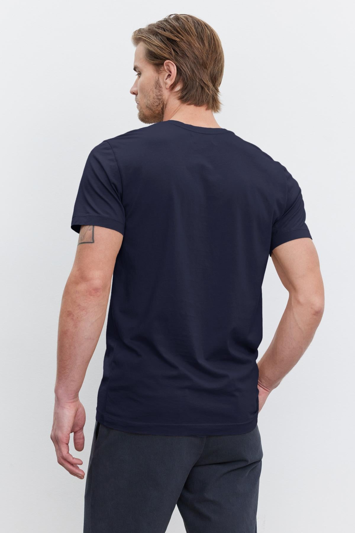   A man wearing a Howard Whisper Classic Crew Neck Tee by Velvet by Graham & Spencer made of lightweight cotton knit with a vintage-feel softness. 