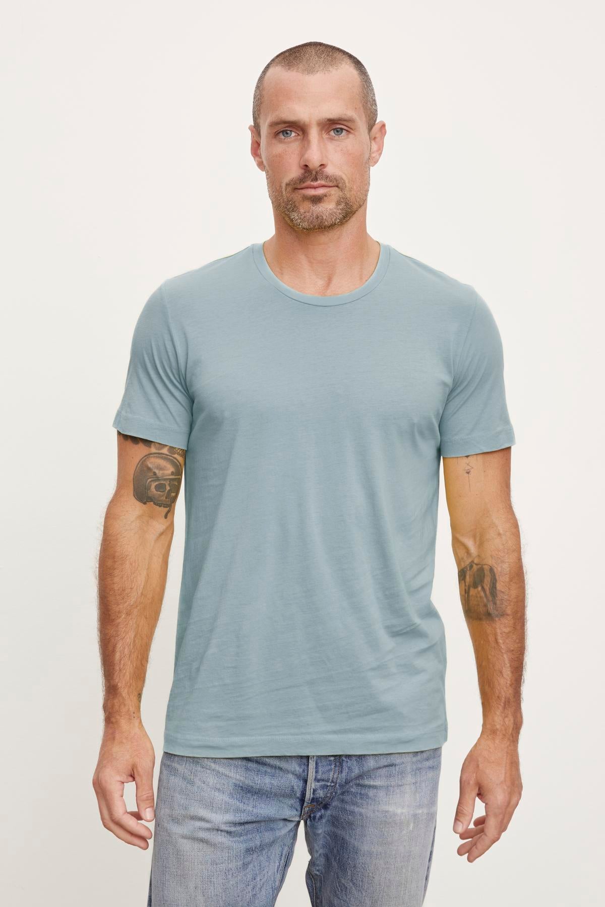 A man wearing a flawless fit HOWARD WHISPER CLASSIC CREW NECK TEE made of lightweight cotton knit by Velvet by Graham & Spencer.-36009113714881