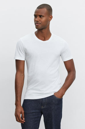 A man wearing a Velvet by Graham & Spencer Howard Whisper Classic Crew Neck Tee, made from a lightweight cotton knit, exuding vintage-feel softness.