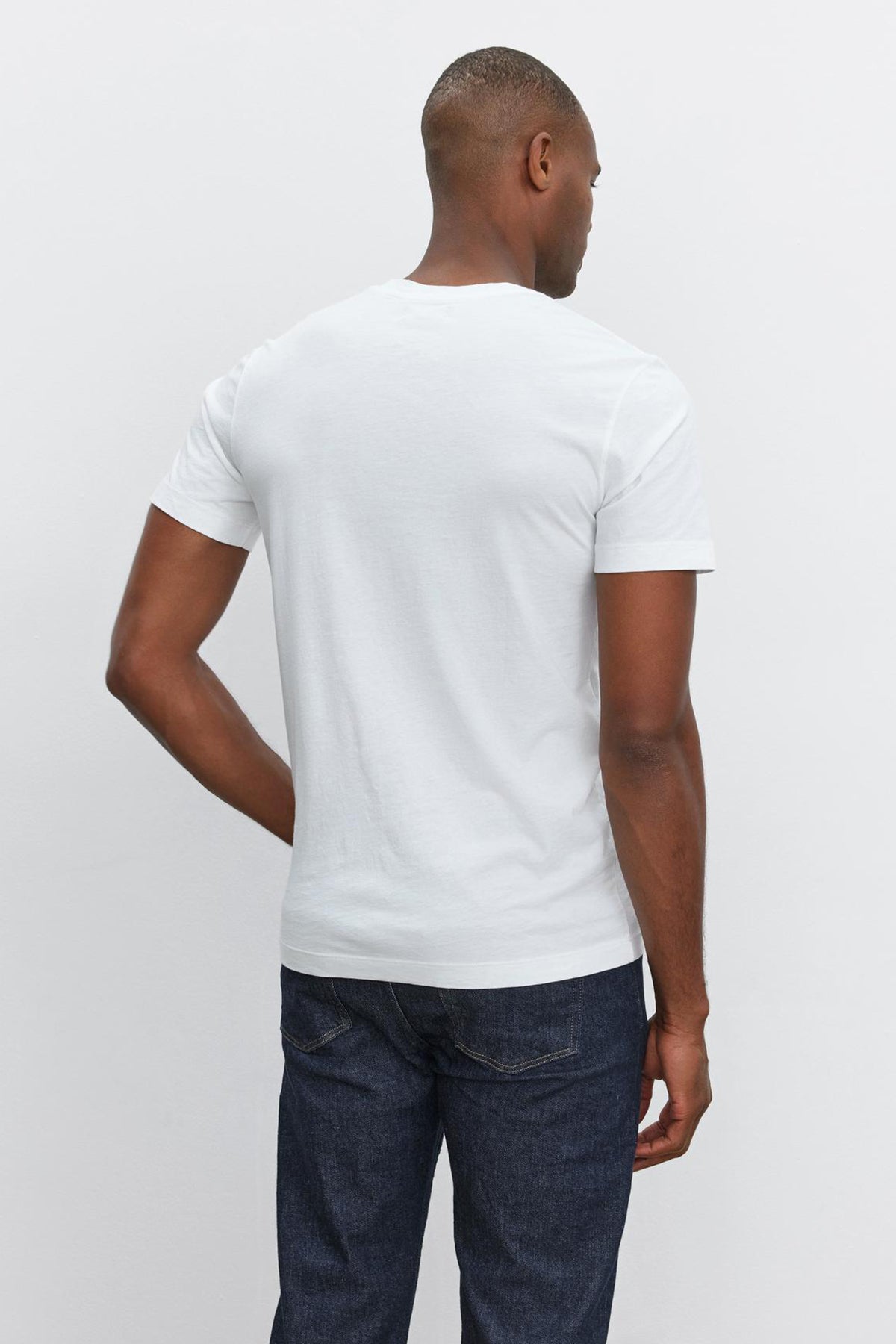 The back of a man wearing jeans and a HOWARD WHISPER CLASSIC CREW NECK TEE made with Velvet by Graham & Spencer's vintage-feel softness.-35867473248449