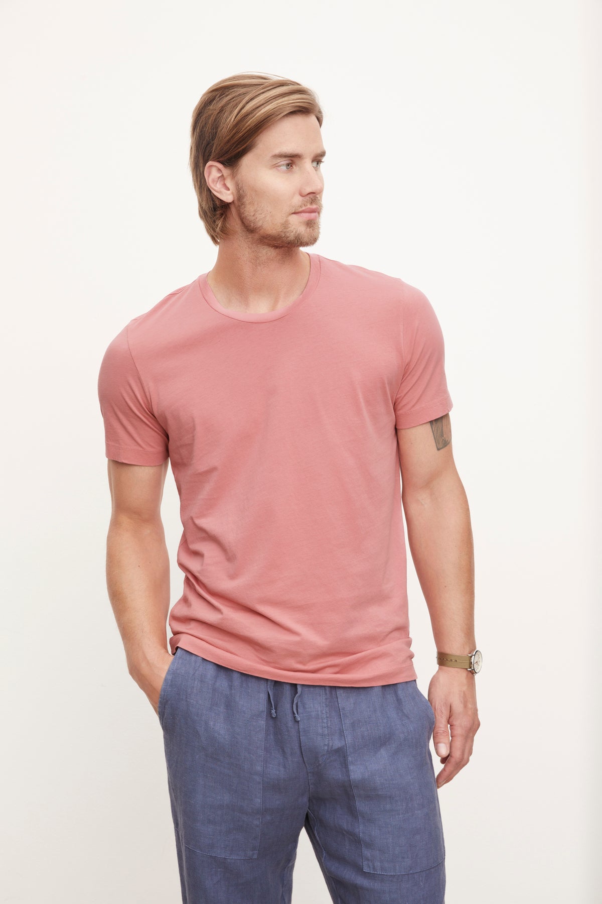  A man wearing a Velvet by Graham & Spencer HOWARD WHISPER CLASSIC CREW NECK TEE and blue pants, showcasing a flawless fit. 