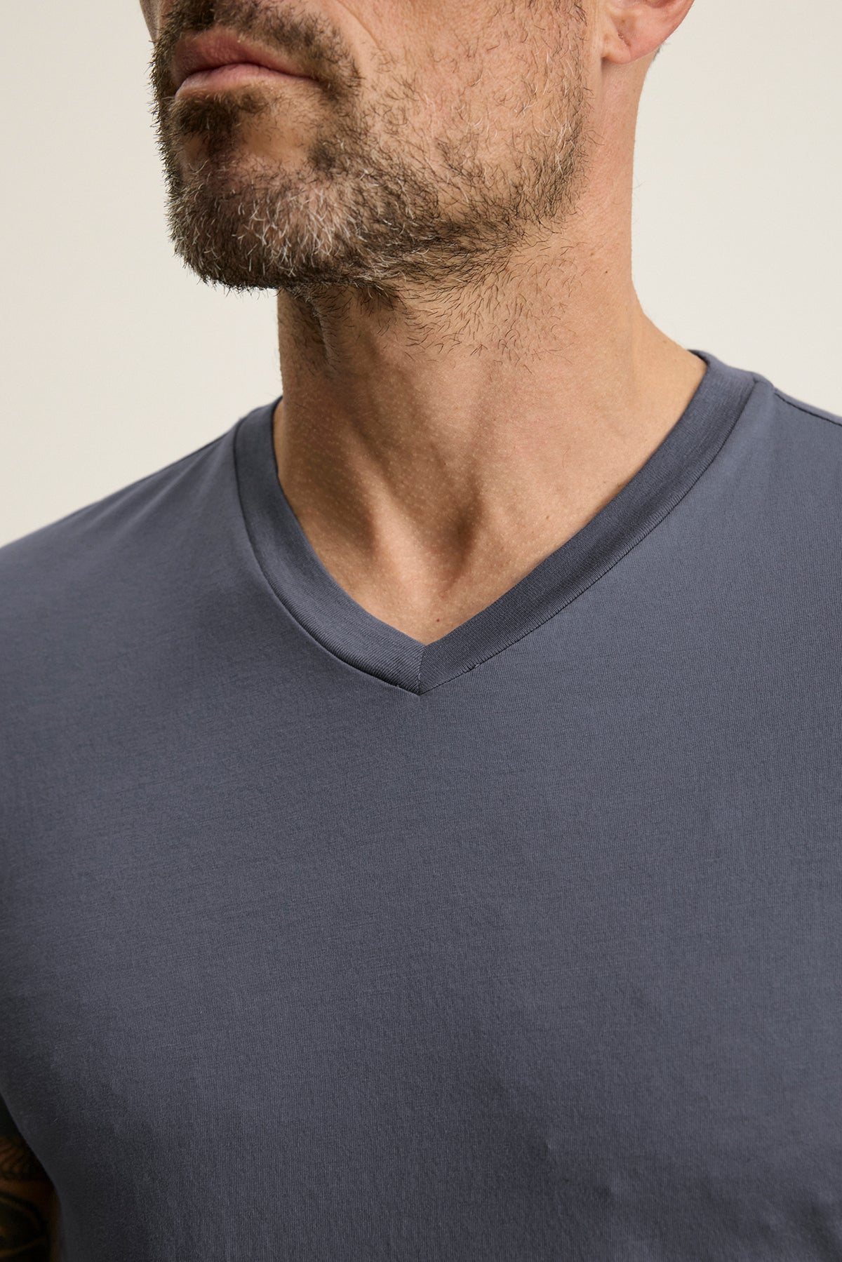   A man with a beard, wearing the SAMSEN TEE by Velvet by Graham & Spencer in gray Pima jersey, is shown from shoulders up, facing slightly left. 