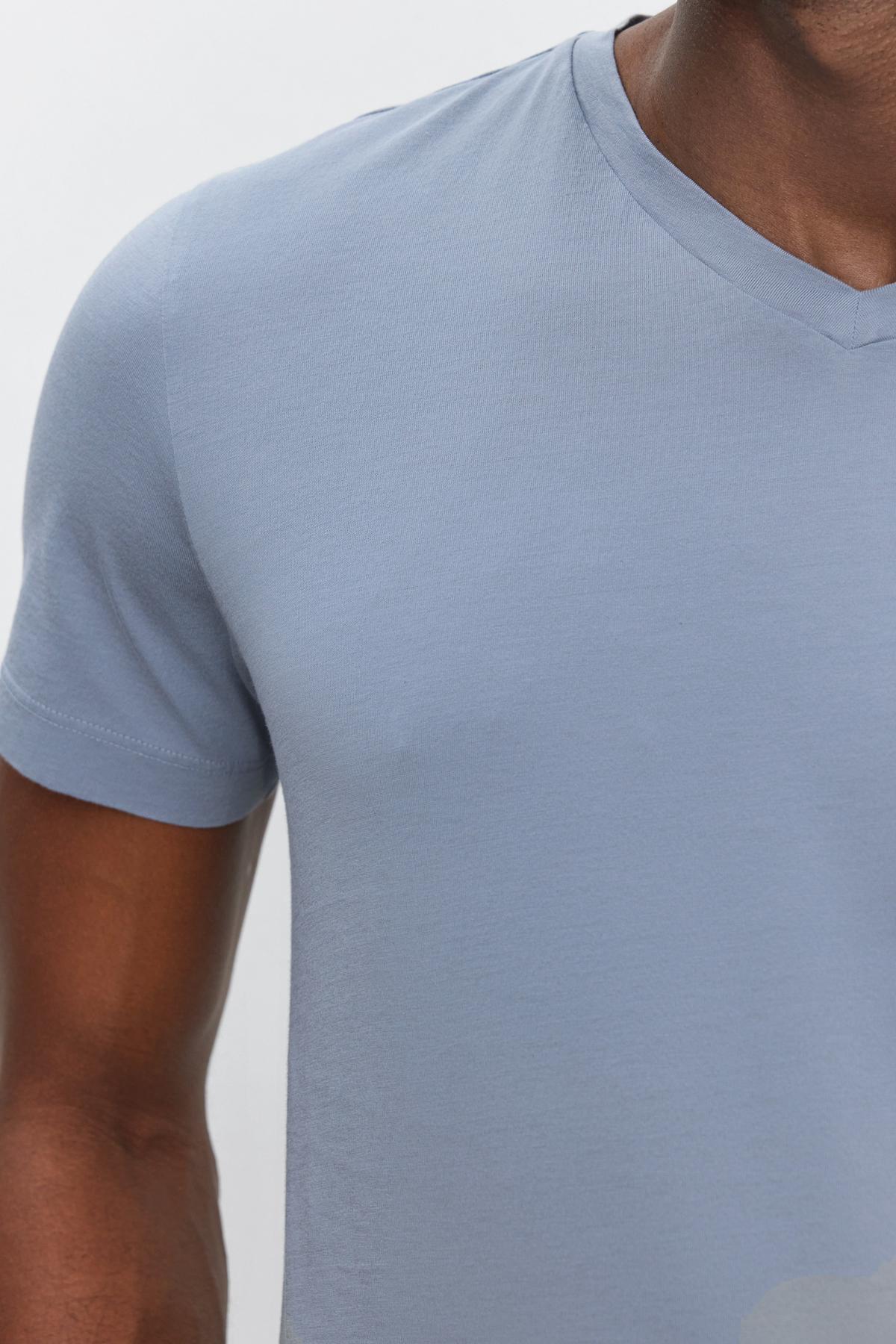 Close-up of a person wearing a SAMSEN TEE by Velvet by Graham & Spencer, showing part of the chest, shoulder, and upper arm against a white background. Perfect for everyday wear.-37386148741313