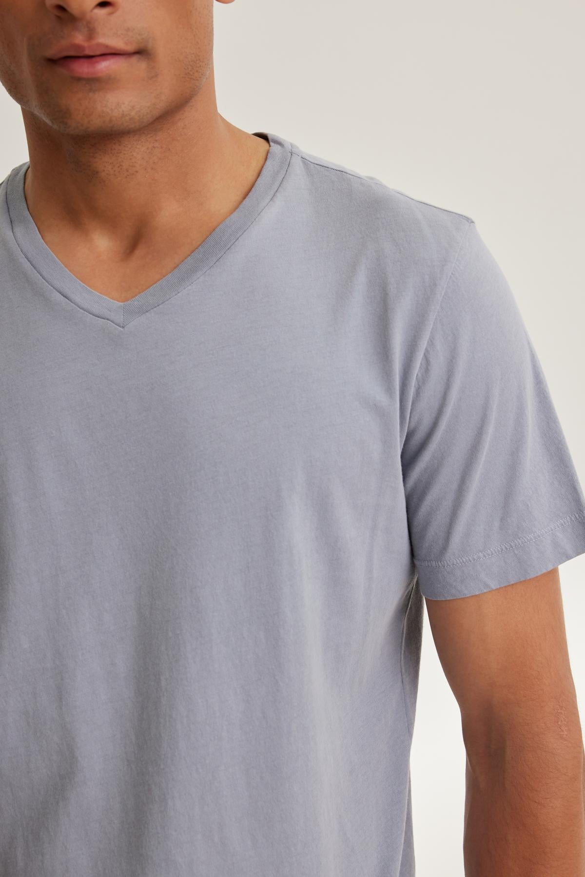 A person wearing the SAMSEN TEE by Velvet by Graham & Spencer, a soft Pima jersey V-neck T-shirt, against a neutral background—ideal for effortless layering.-38643347488961